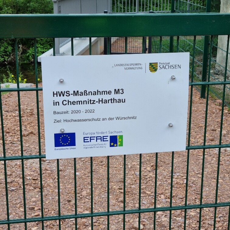 Schild zum EFRE-Projekt an einem grünen Zaun