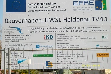 Bautafel hinter einem Bauzaun