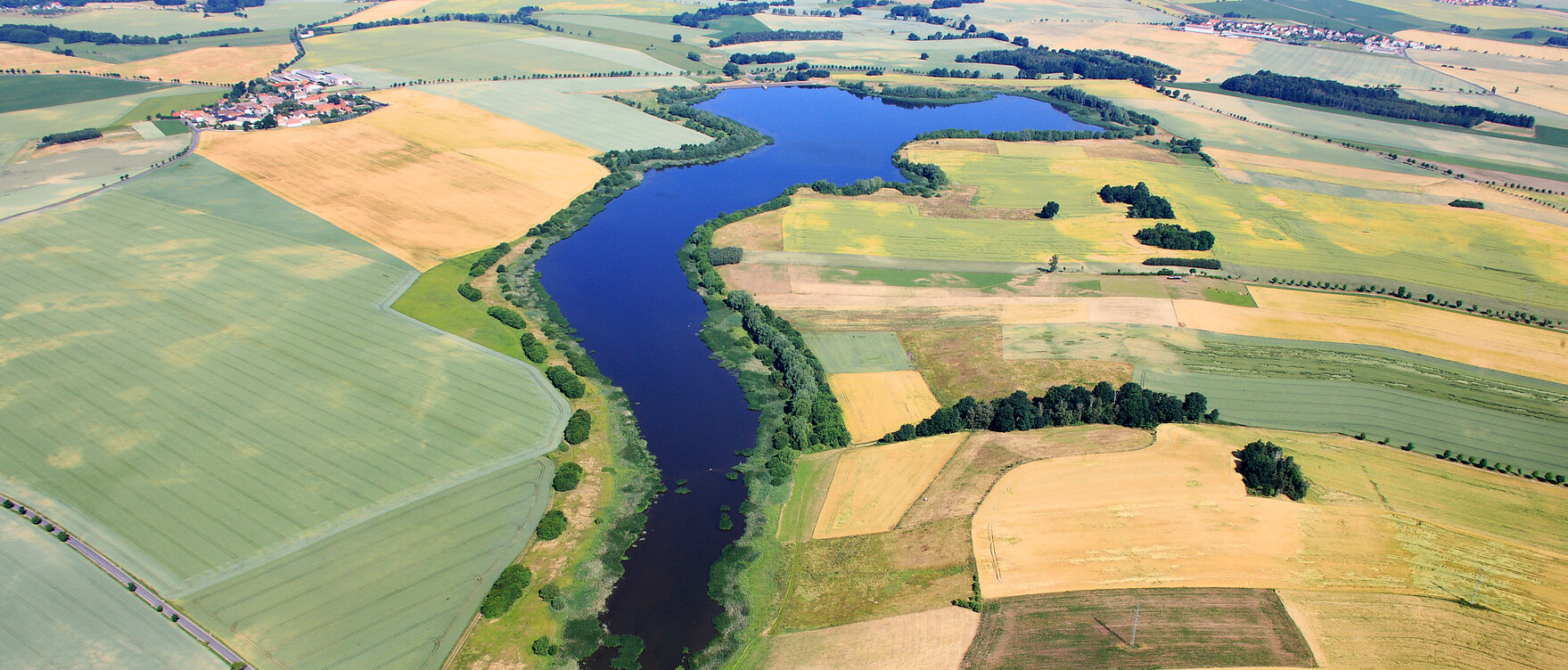 Luftbild der Talsperre Nauleis, umgeben von Feldern