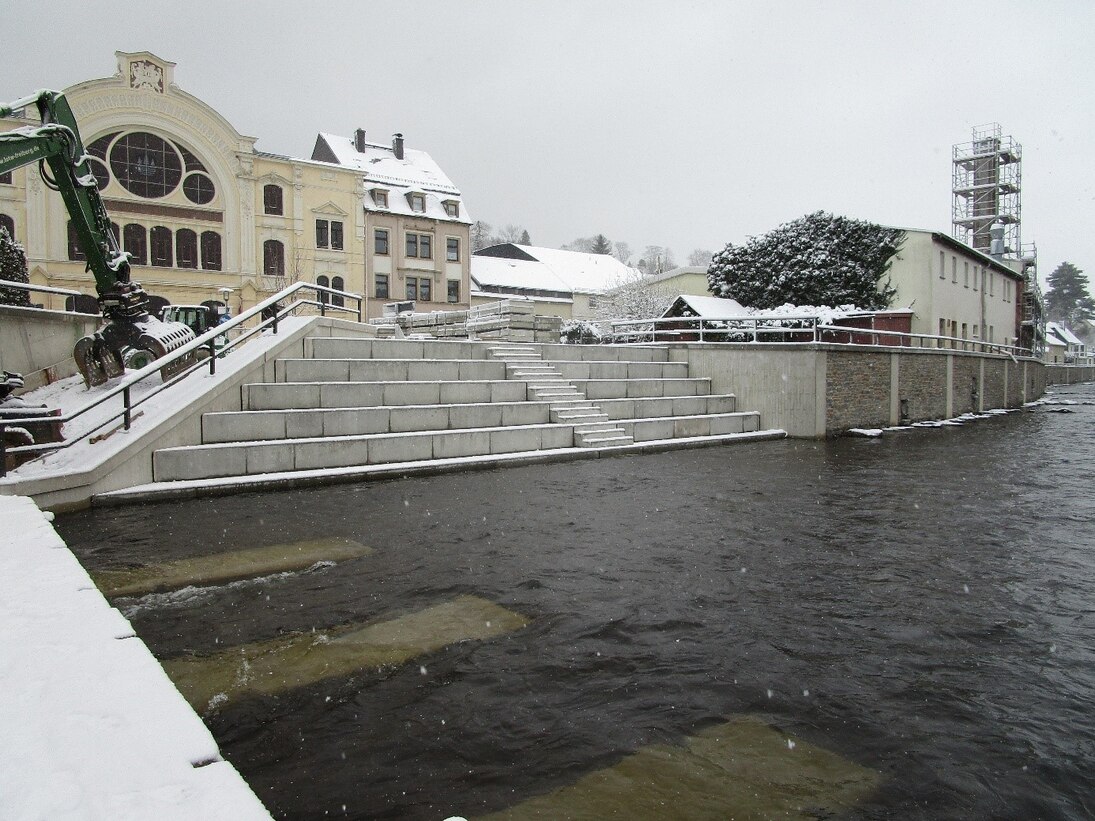 Fluss, Freitreppe und dahinterliegende Gebäude im Winter