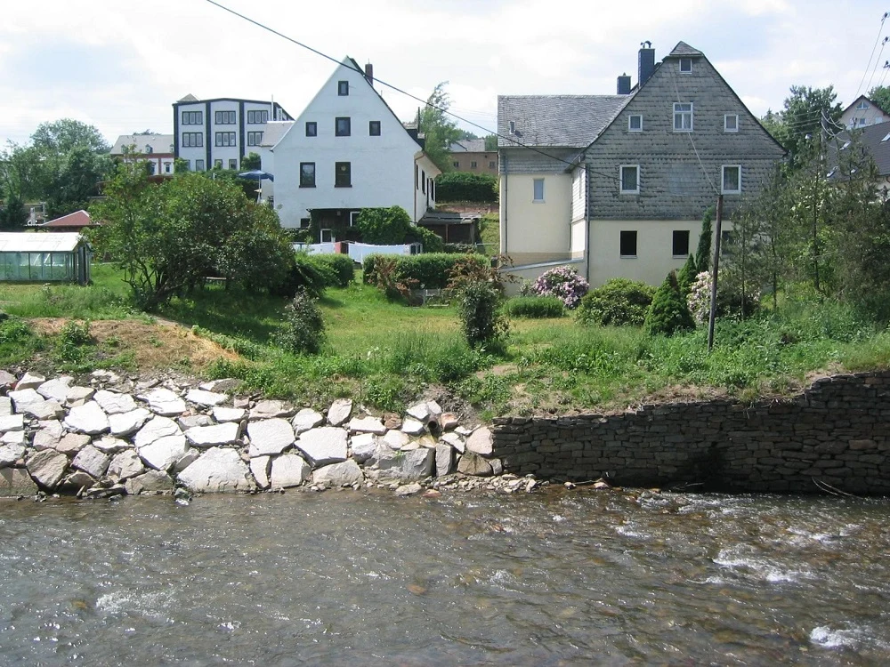 Blick über Fluss ans andere Ufer mit Häusern
