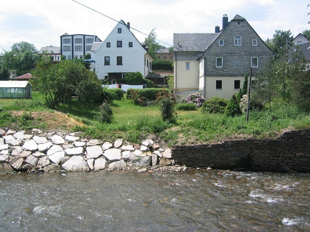 Blick über Fluss ans andere Ufer mit Häusern