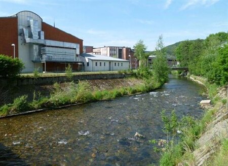 Fluss mit Gebäuden entlang des linken Ufers