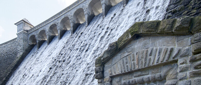 Nahaufnahme der Staumauer der Talsperre Neunzehnhain 2, über die Wasser aus der Anlage fließt