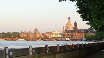 Blick vom Elbeflussufer hinter mobilen Hochwasserschutzwänden auf die Stadtkulisse Dresdens