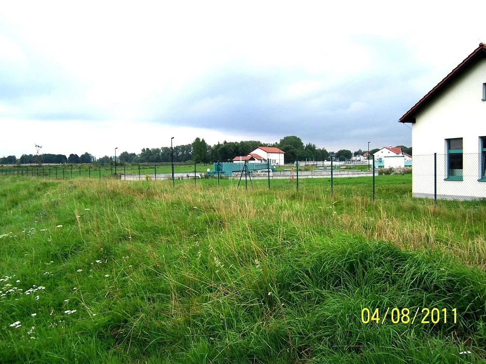 Wiese und ein umzäuntes Haus