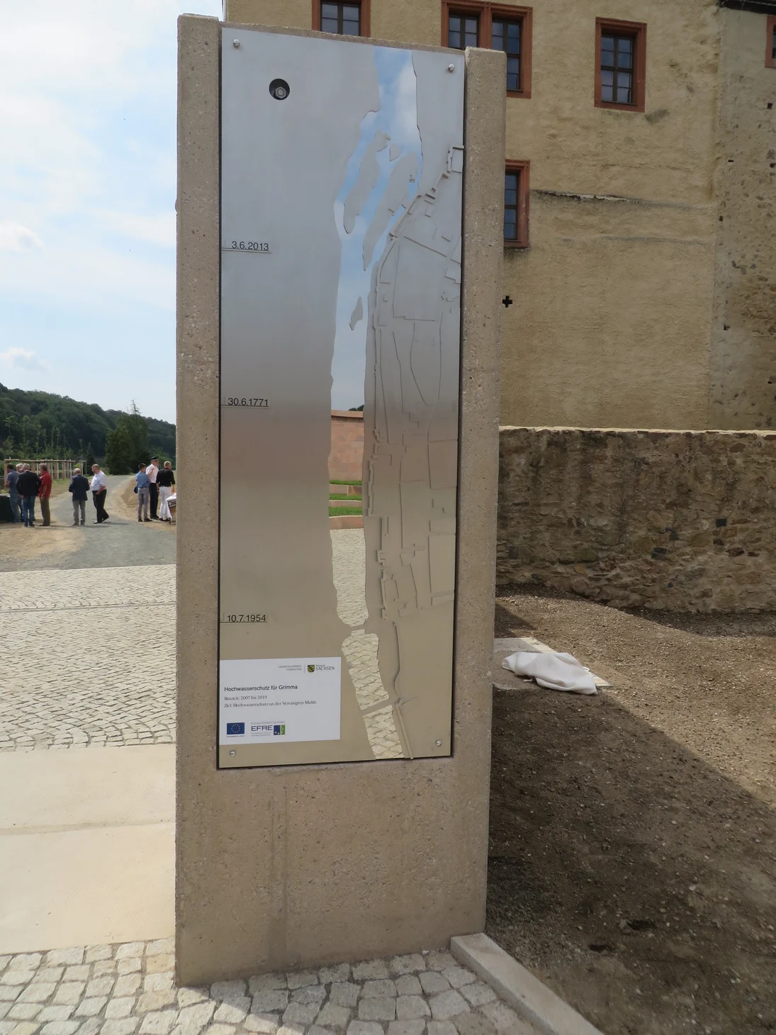 eine in Sandstein eingefasste silberne Karte eines Flusses und angerissener Stadt mit Jahreszahl-Markierungen
