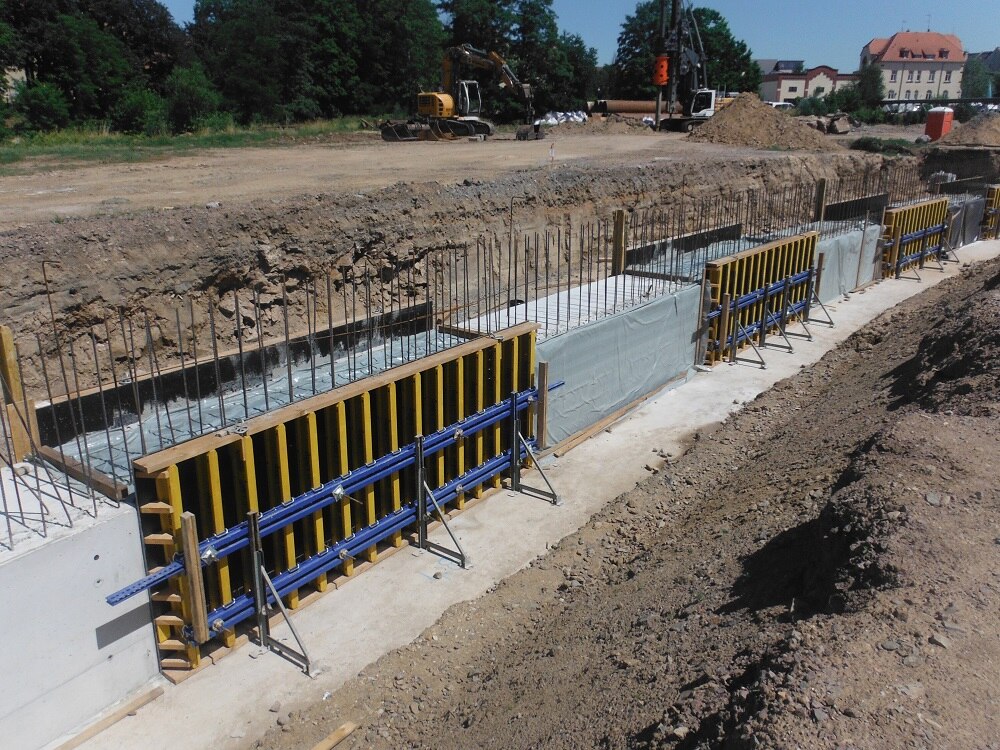 in einen Graben eingelassene noch eingerüstete niedrige Betonwand