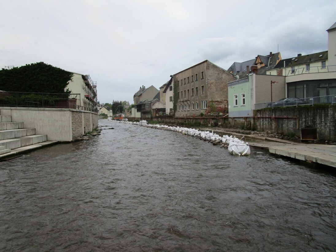 Sandsäcke liegen am Flussufer