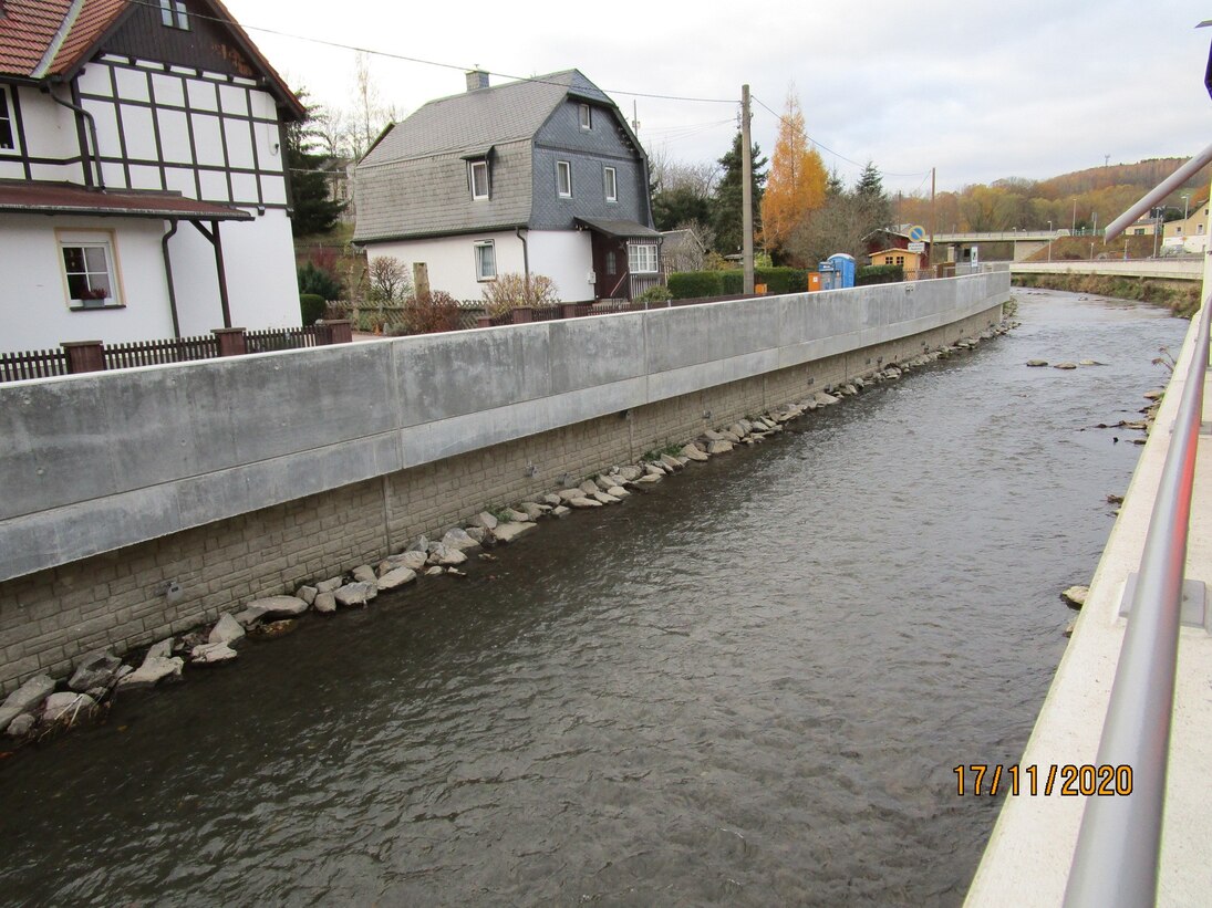 Blick auf Fluss, dahinter Häuser