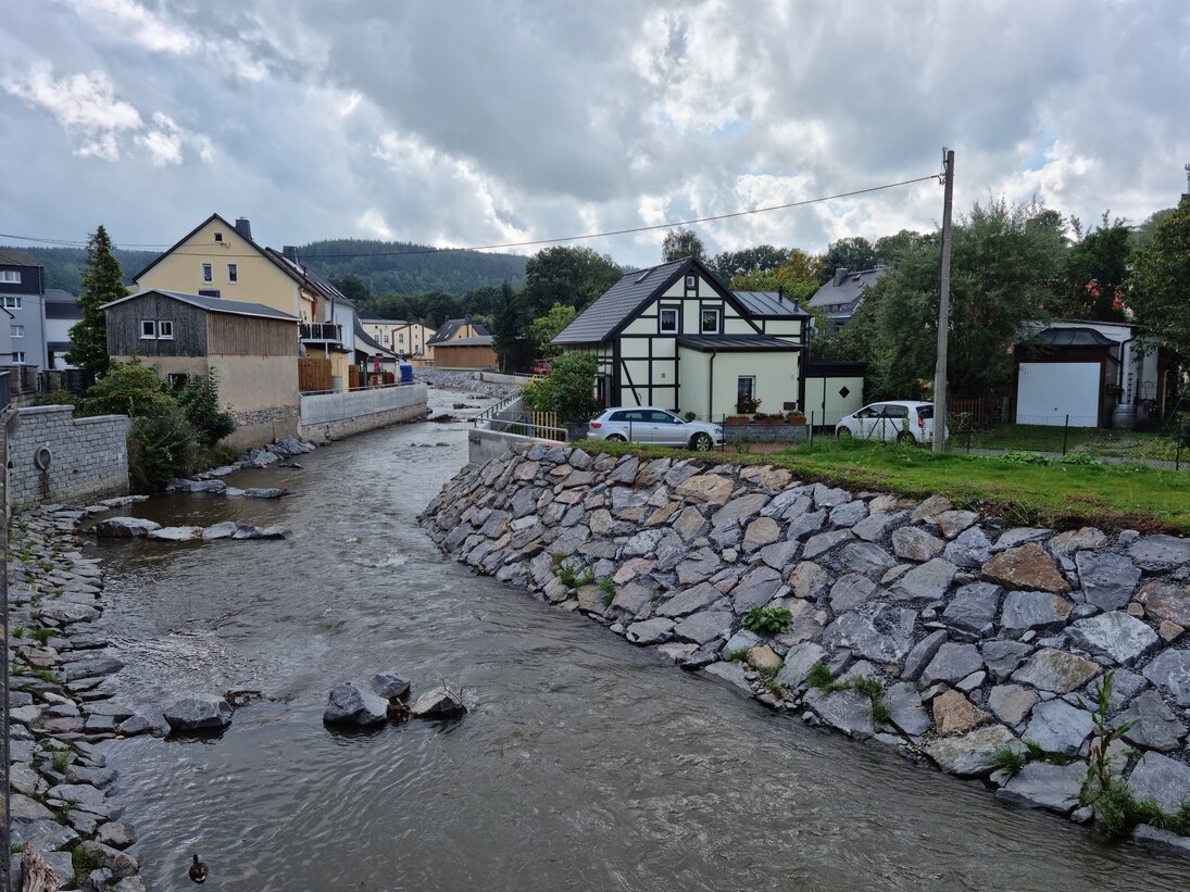 Blick auf Fluss mit steinerner Böschung