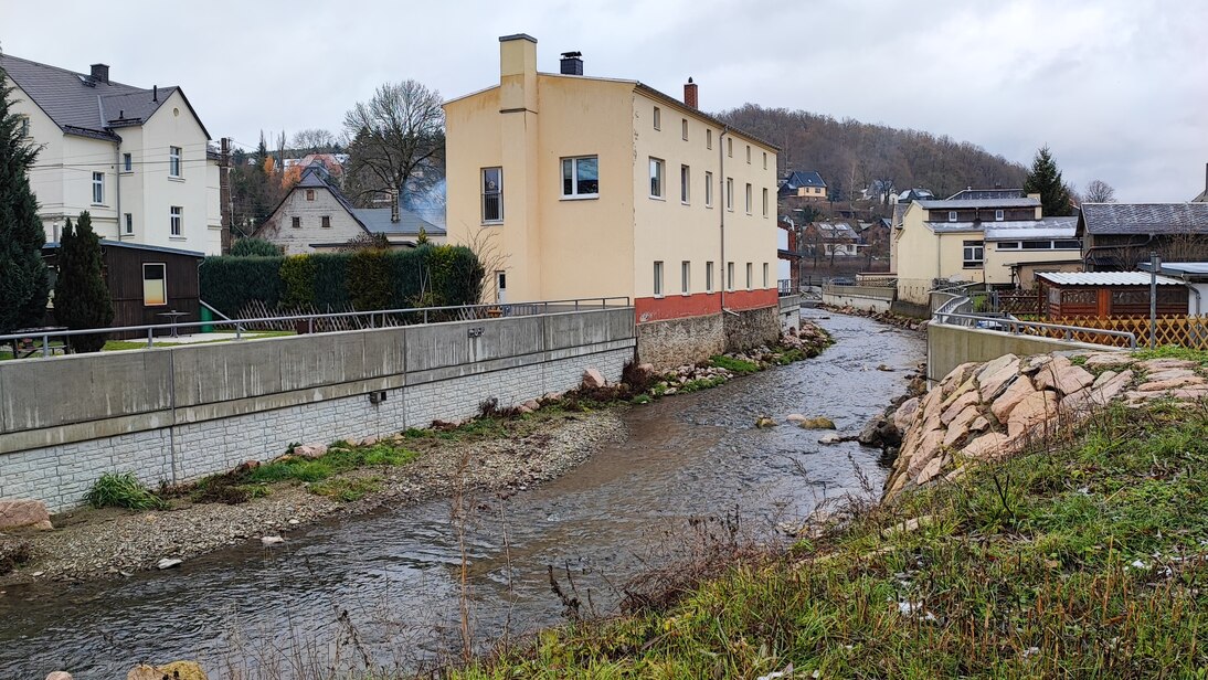 Blick auf Fluss, dahinter Bebauung