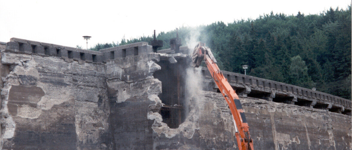 Blick auf eine alte Mauer in die ein Bagger ein Loch gerissen hat