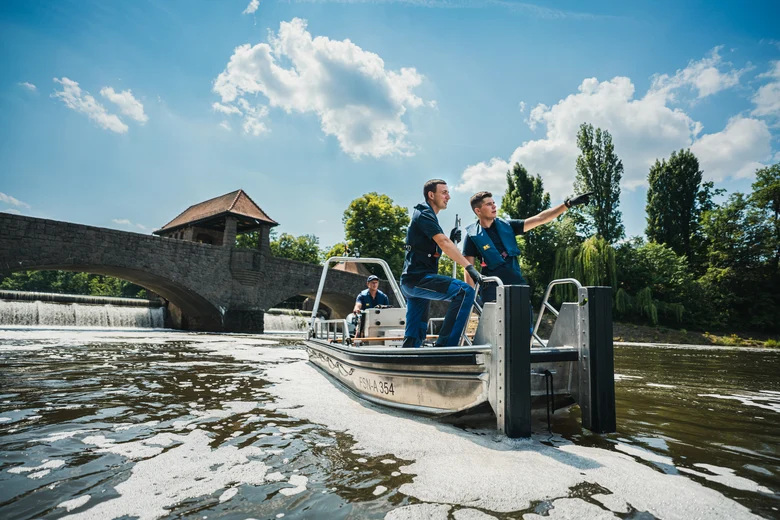 zwei Männer stehen in einem Boot auf dem Wasser und schauen gemeinsam in eine Richtung