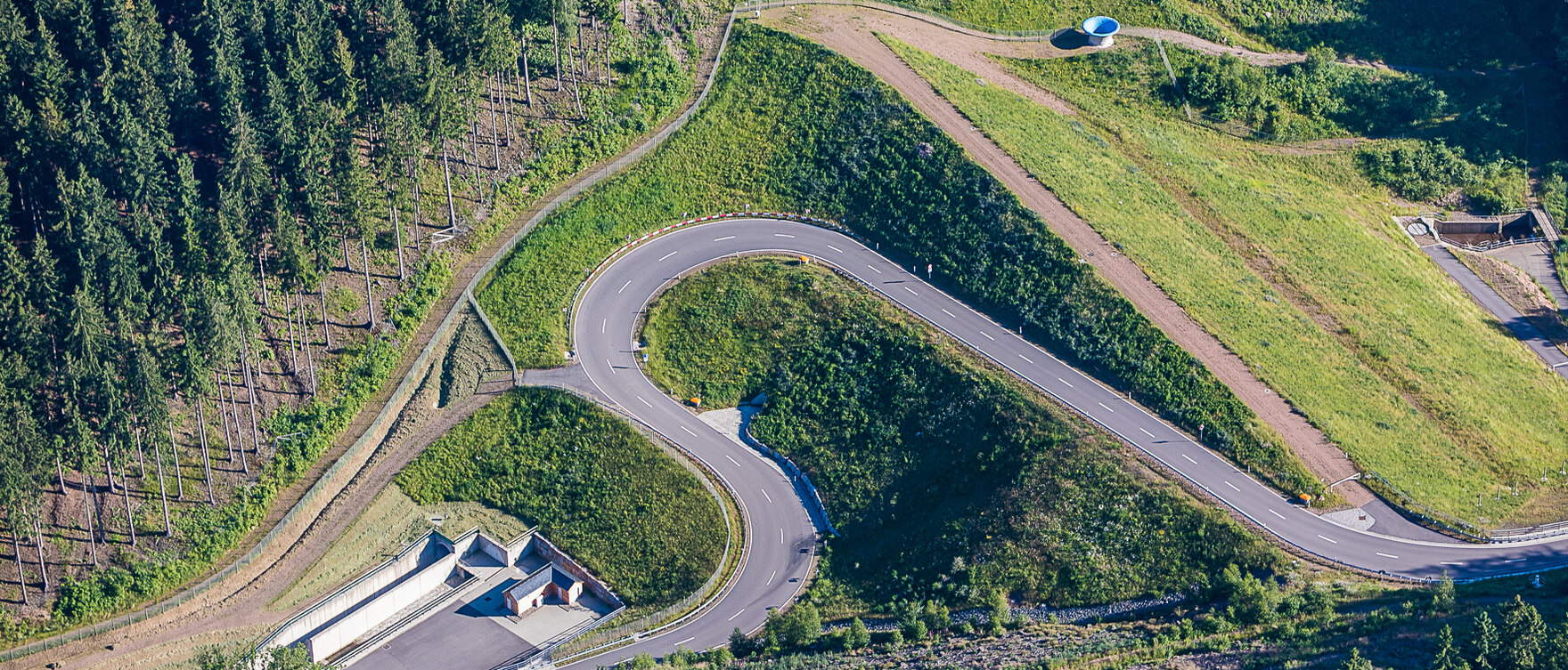 Luftbild auf eine Serpentinenstraße im Grünen