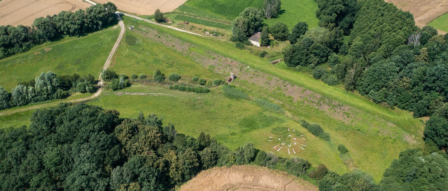 Luftbild von grünen Hochwasserrückhaltebecken, umgeben von Feldern
