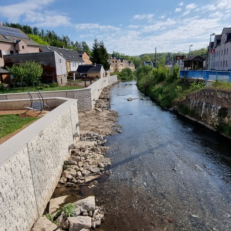 Blick auf Fluss mit Mauer links