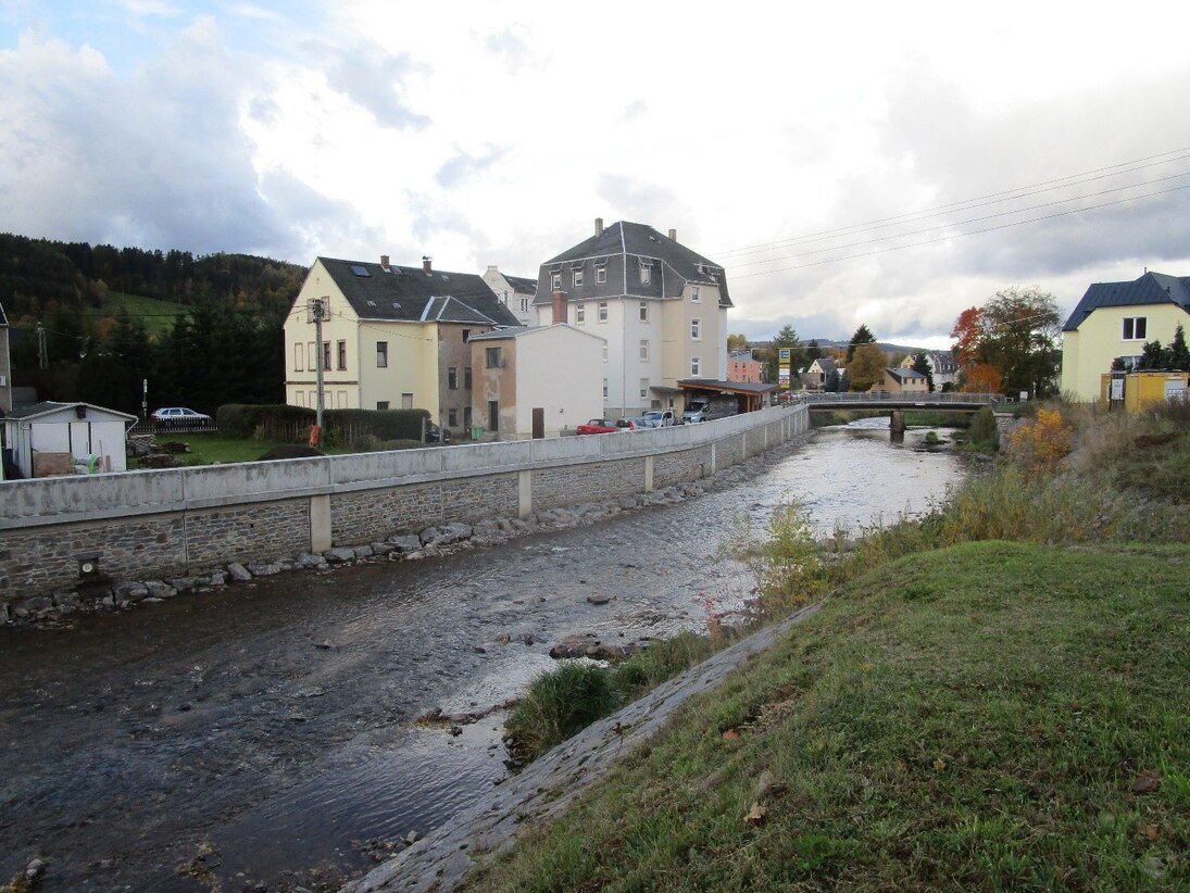 Blick auf die fertiggestellten Hochwasserschutzanlagen am Fluss