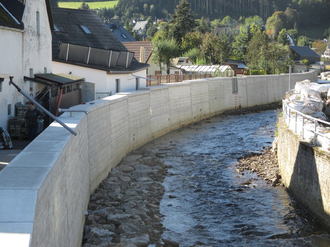 Blick auf Fluss mit Hochwasserschutzmauer links