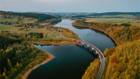 Luftbild der Talsperre Rauschenbach mit einer Straßenbrücke über das gestaute Wasser