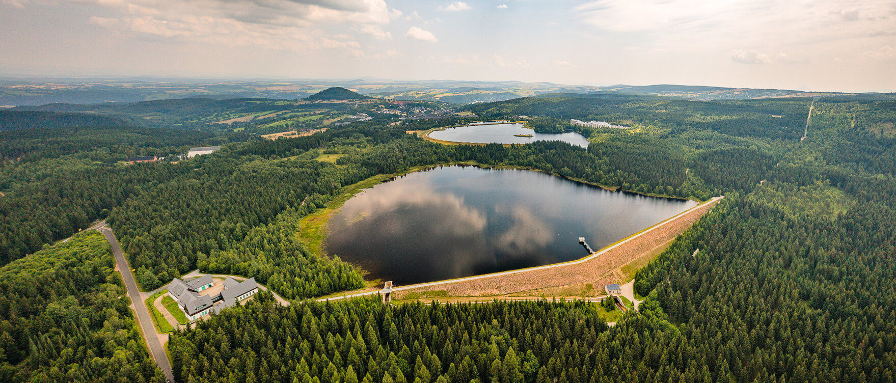 Luftbild von der Talsperre, umringt von Wald