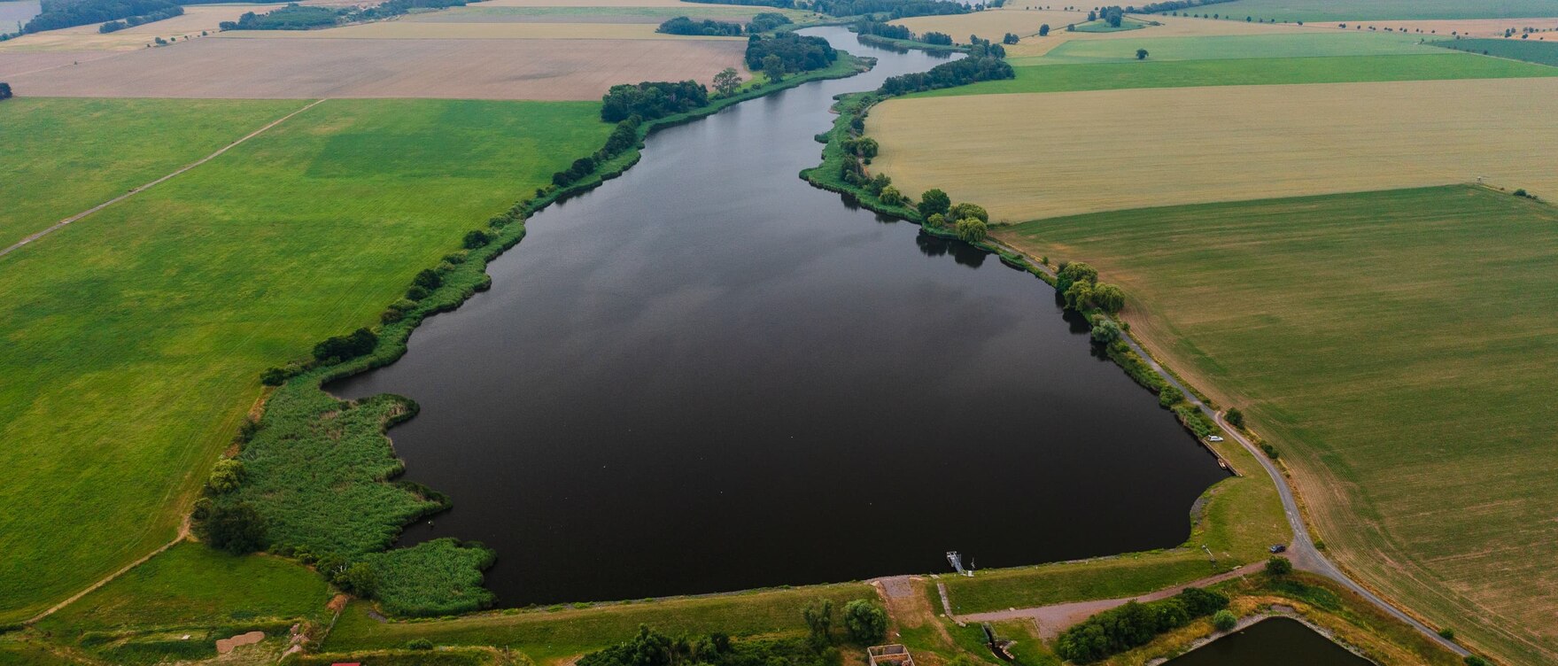 Luftbild der Talsperre - ein See zwischen Feldern
