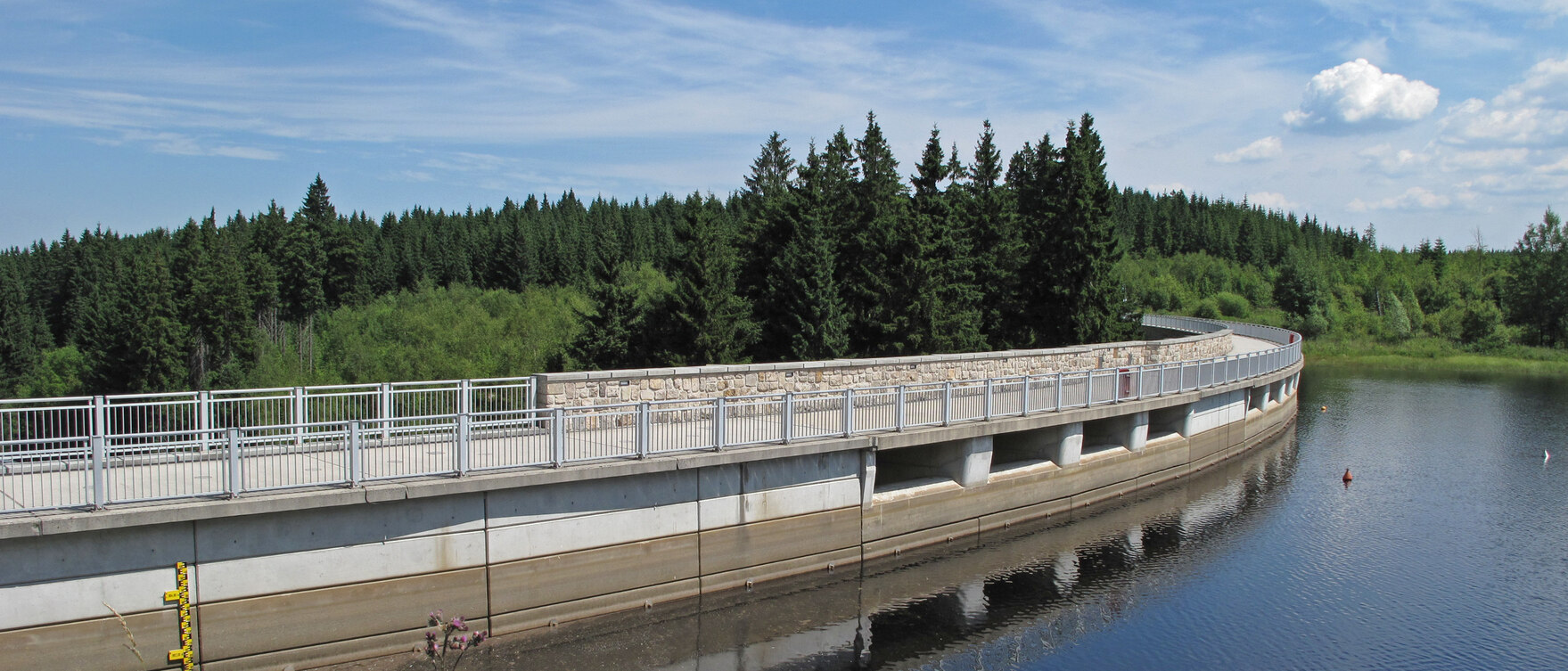 Blick auf die Mauerkrone der Talsperre samt eingestautem Wasser