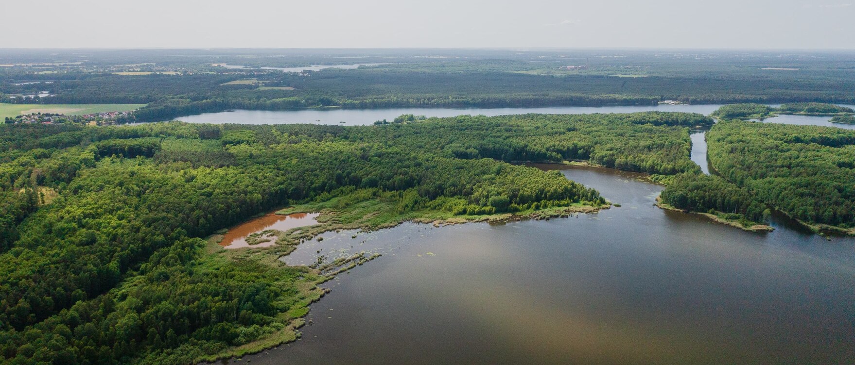 Luftbild zweier Seen, die durch Wald getrennt sind